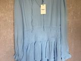 the blue dress is hanging on a hanger on the wall