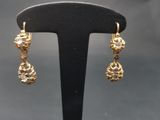 gros plan d'une paire de boucles d'oreilles sur un support