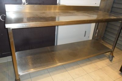 une table en acier inoxydable avec deux étagères dans la cuisine