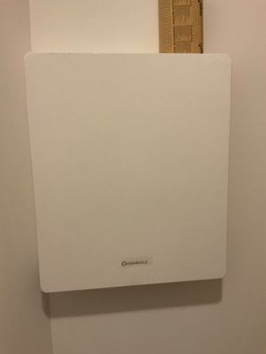 une photo d'une salle de bains avec des toilettes et un distributeur de papier accroché au mur