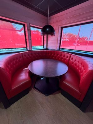 une table ronde dans un coin d'une cabine aux murs rouges