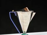 an image of a silver trophy with a blue handle on a white table