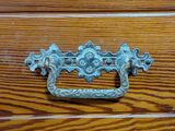 a close up of a metal handle on a wooden cabinet