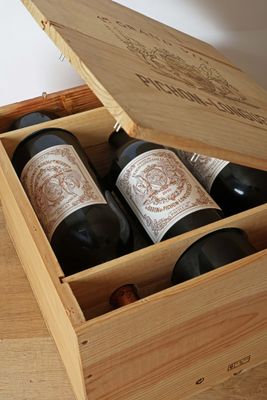 three bottles of wine in a wooden box on a table