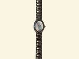a watch that is sitting on top of a metal bracelet