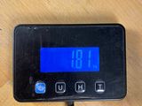 a digital clock on a table with a charger
