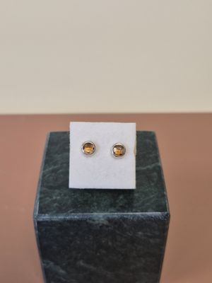 une paire de boucles d'oreilles posée sur une boîte noire
