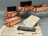 cinq petits wagons posés sur une feuille de papier