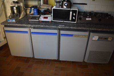 une petite cuisine avec un micro-ondes posé sur le plan de travail