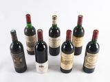 several bottles of wine are lined up on a white surface