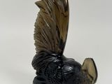 a black and brown bird figurine sitting on a white surface