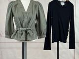 two women ' s tops on a mannequin stand in front of a white wall
