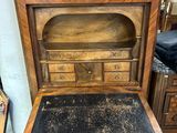 un très vieux bureau en bois avec un plateau noir