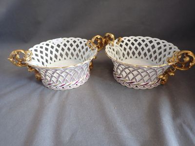 a pair of white and gold handled baskets with handles