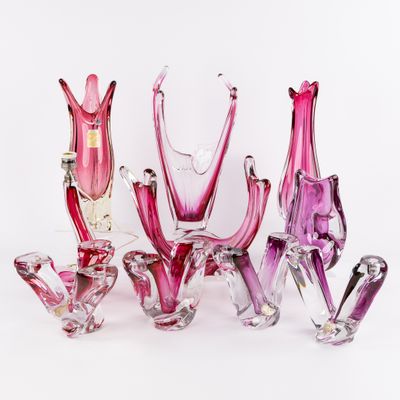 un ensemble de vases en verre rose disposés les uns à côté des autres