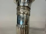 a silver vase that is sitting on a table