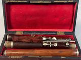 une image représentant un ensemble de trois pipes en bois dans un étui