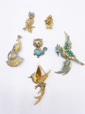 a group of five brooches of various shapes and sizes