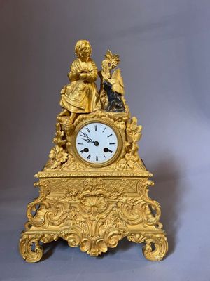 a gold clock with a statue on top of it