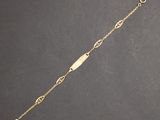 a gold plated bracelet with a bar on a chain