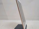 the tablet is sitting on a stand on a white surface