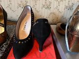 pair of black high heeled shoes sitting on top of a red box