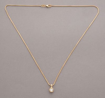 a gold necklace with a white stone pendant