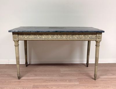 une photo d'une table au plateau en marbre posée sur un parquet en bois massif