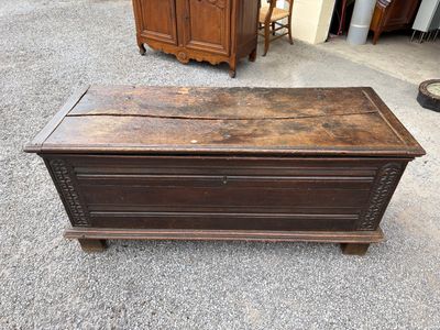 an old wooden chest sitting on top of a gravel floor