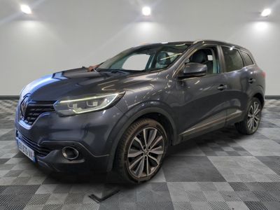 a grey car is parked on a checkered floor in a garage