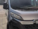 the front of a silver van is parked in a parking lot
