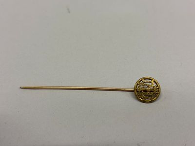 un gros plan d'une broche en or ornée d'une fleur