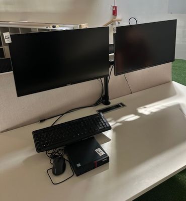 a desk with two monitors and a keyboard on it