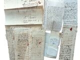 plusieurs morceaux de vieux papier portant des inscriptions, posés sur une surface blanche
