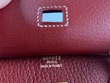 someone is holding a red purse with a gold lock on it