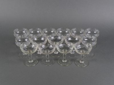 six verres à vin transparents alignés en rang sur une surface grise