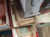a stack of books on the floor next to a refrigerator