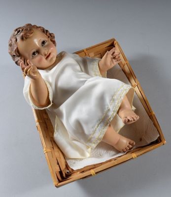 une poupée dans un panier posé sur une table