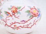 a white tea pot with a floral design on it