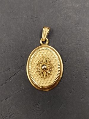 a small gold locke with a diamond in the center