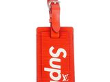 red supreme luggage tag with white supreme logo on it