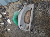 a broken toilet sitting on the ground next to a trash can