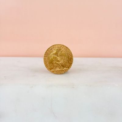a gold coin sitting on top of a marble counter top