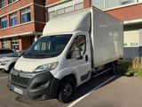 un camion blanc garé sur un parking à côté d'un immeuble