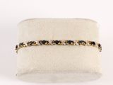 un gros plan sur un bracelet orné de pierres noires et blanches