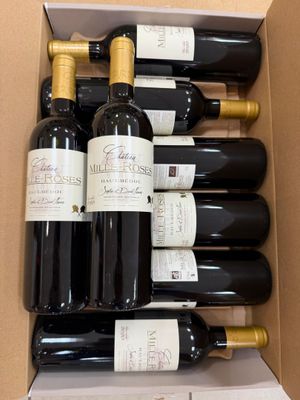 six bouteilles de vin dans un carton sur la table