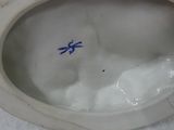 a close up of a white porcelain bowl with a blue handle