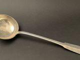 an old silver spoon with a spoon handle on a black surface