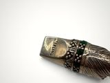 a close up of a metal object with a feather on it