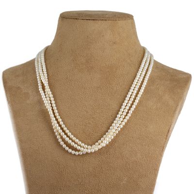 un collier de perles à trois rangs sur le torse d'un mannequin